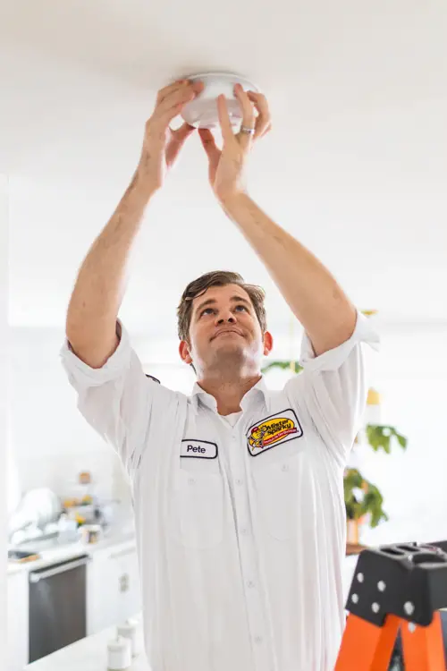 Pete, an electrician at Mister Spark, installing a smoke detector